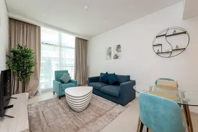 a living room with blue chairs and a table at Seven Palms in Dubai