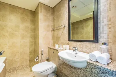 a bathroom with a sink and a toilet and a mirror at Exclusive Studio at Sky Gardens, DIFC by Deluxe Holiday Homes in Dubai