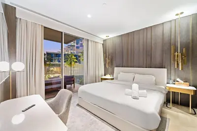 a bedroom with a large white bed and a desk at Five Palm Luxury - 2BR with Pool View, Gym & Prime Beach Stay in Dubai
