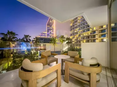 a room with a balcony with a table and chairs at Five Palm Luxury - 2BR with Pool View, Gym & Prime Beach Stay in Dubai