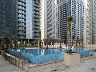 a large swimming pool in a city with tall buildings at Stylish 3BR Apartment in Dubai Marina with Pool, Gym, and Views in Dubai