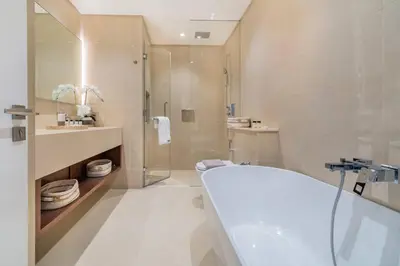 a bathroom with a tub and a sink and a shower at Stylish 3BR Apartment in Dubai Marina with Pool, Gym, and Views in Dubai