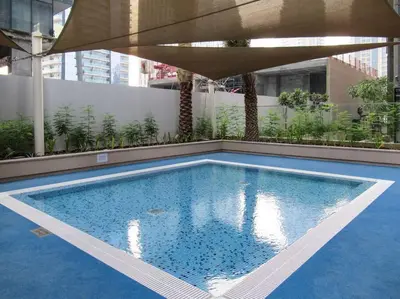 a swimming pool on top of a building with an umbrella at Stylish 3BR Apartment in Dubai Marina with Pool, Gym, and Views in Dubai