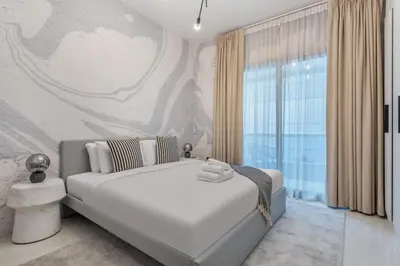 a bedroom with a bed and a large window at Comfy 1BR Marina Living Steps from Marina Walk in Dubai