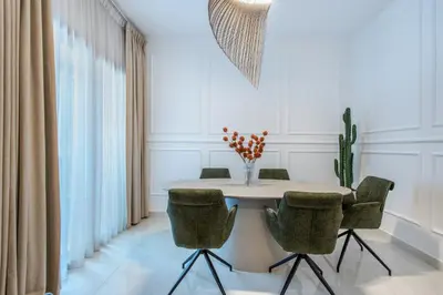 a dining room with a white table and chairs at Comfy 1BR Marina Living Steps from Marina Walk in Dubai