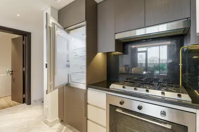 a kitchen with a stove top oven next to a window at Upscale 2BR with Private Terrace & Pool View in Dubai