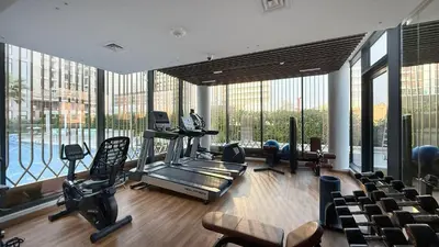 a gym with exercise equipment and large windows at Upscale 2BR with Private Terrace & Pool View in Dubai