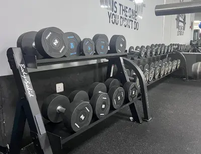 a row of dumbbell racks in a gym at Stunning Panoramic Sea & Marina City Skyline View in Dubai