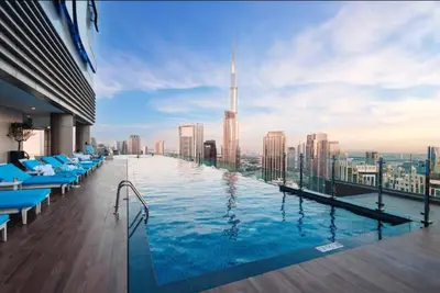 a pool on the roof of a building with a view at 64th Floor Highest Downtown Infinity Pool Burj Khalifa View in Dubai
