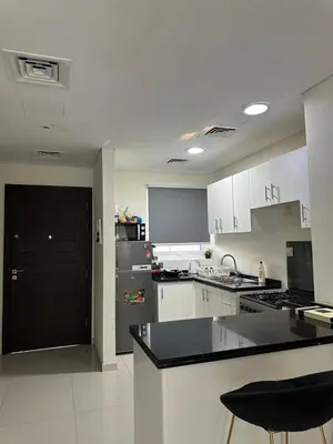 a kitchen with white cabinets and a black counter top at Villa Townhouse in Dubai