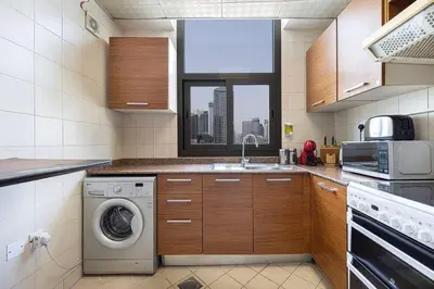 a kitchen with a washing machine and a window at Classic Charm a Studio with Iconic Marina Views in Dubai