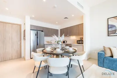 a kitchen and dining room with a table and chairs at Captivating 2BR Apartment in Park Ridge Tower C , Dubai Hills Estate by Deluxe Holiday Homes in Dubai