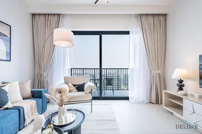 a living room with a blue couch and a table at Captivating 2BR Apartment in Park Ridge Tower C , Dubai Hills Estate by Deluxe Holiday Homes in Dubai