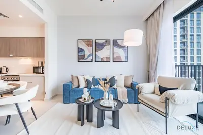 a living room with a blue couch and chairs at Captivating 2BR Apartment in Park Ridge Tower C , Dubai Hills Estate by Deluxe Holiday Homes in Dubai