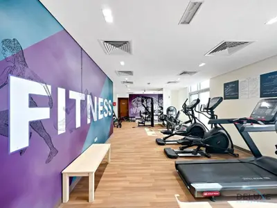 a gym with treadmills and cardio equipment in a room at Stunning Studio Apartment in Azizi Star , Jebel Ali by Deluxe Holiday Homes in Dubai