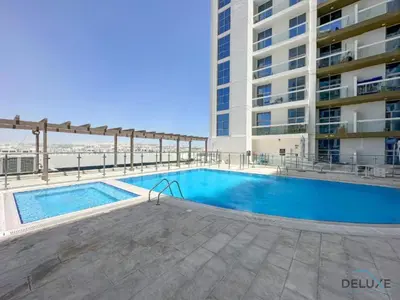 a swimming pool in front of a building at Stunning Studio Apartment in Azizi Star , Jebel Ali by Deluxe Holiday Homes in Dubai