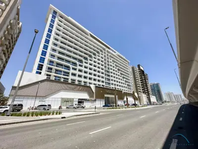 a large building on the side of a street at Stunning Studio Apartment in Azizi Star , Jebel Ali by Deluxe Holiday Homes in Dubai