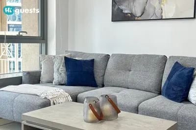 a living room with a gray couch with blue pillows at HiGuests - Exclusive Downtown Dubai 1BR Apt at 29 Boulevard in Dubai