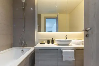 a bathroom with a sink and a tub and a mirror at Dubai Creek - Bright & Beautiful 1BR in The Cove in Dubai