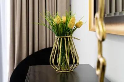 a vase filled with yellow flowers on a table at Dubai Creek - Bright & Beautiful 1BR in The Cove in Dubai