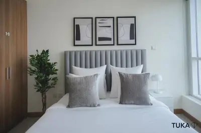 a bedroom with a white bed with four pillows at 3-BHK - Dubai Marina - 44th Floor - 5mins to beach in Dubai