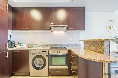 a kitchen with a washer and dryer in it at Stylish Studio at Sky Gardens, DIFC by Deluxe Holiday Homes in Dubai