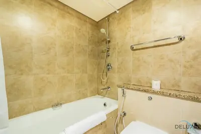 a bathroom with a tub and a toilet and a shower at Stylish Studio at Sky Gardens, DIFC by Deluxe Holiday Homes in Dubai