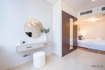 a white bathroom with a mirror and a bed at Stylish Studio at Sky Gardens, DIFC by Deluxe Holiday Homes in Dubai