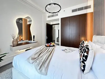 a bedroom with a large white bed and a chandelier at Trophy - Ultra Luxury Suite with Fireplace in Dubai