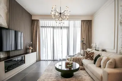 a living room with a couch and a chandelier at Trophy - Ultra Luxury Suite with Fireplace in Dubai