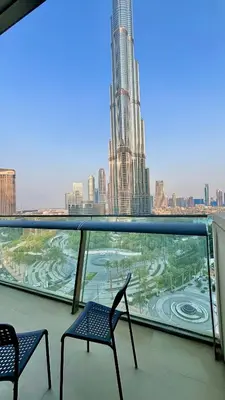 a balcony with two chairs and a view of a city at Stunning Burj Khalifa & Fountain view - Dubai Mall Access, Burj vista Downtown Dubai in Dubai