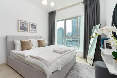 a bedroom with a large bed and a large window at Gala Guests - Stunning Front-Row Marina Views at The Point in Dubai