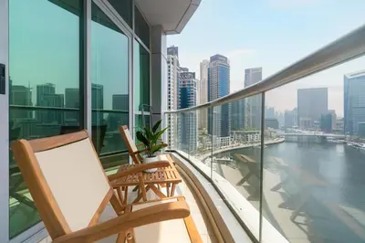 two chairs on a balcony with a view of a city at Gala Guests - Stunning Front-Row Marina Views at The Point in Dubai