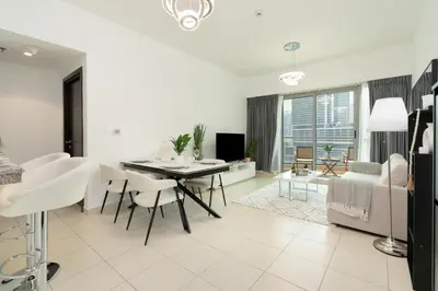 a white living room with a table and chairs at Gala Guests - Stunning Front-Row Marina Views at The Point in Dubai
