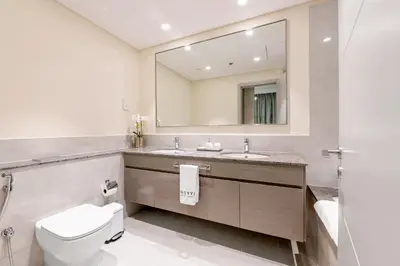 a bathroom with a toilet and a large mirror at Stylish 2BR in Forte 2 in Dubai