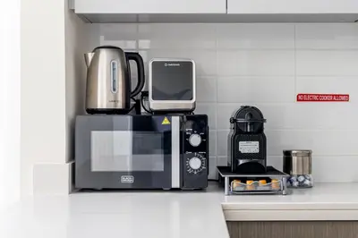 a coffeemaker and a microwave on a kitchen counter at Stylish 2BR in Forte 2 in Dubai