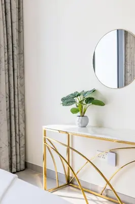 a dressing table with a mirror and a potted plant at Stylish 2BR in Forte 2 in Dubai