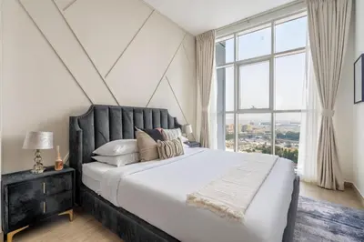 a bedroom with a large bed with a large window at GuestReady - Lux nest near JBR beach in Dubai