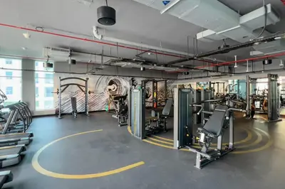 a gym with treadmills and machines in a room at GuestReady - Lux nest near JBR beach in Dubai