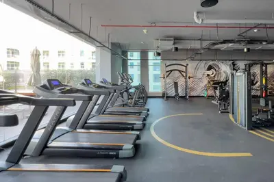 a row of treadmills in a gym at GuestReady - Lux nest near JBR beach in Dubai