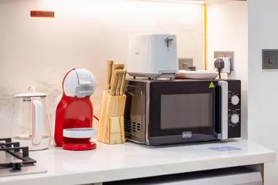 a kitchen counter with a coffee maker and a microwave at Daniels Poolside Studio in Meydan in Dubai