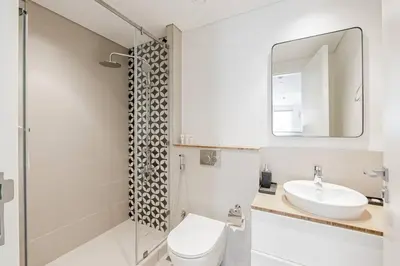 a bathroom with a sink and a toilet and a mirror at Luxury at Socio Dubai Hills, 2 Beds, Sleeps 4 - DVH Holiday Homes in Dubai