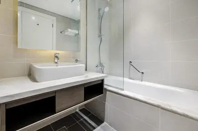 a bathroom with a sink and a shower and a tub at A Living-Modern Studio Apartment with Balcony & Canal view at Prive 2507B ,Business Bay in Dubai