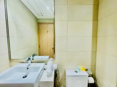 a bathroom with a sink and a toilet and a mirror at Venduras - Modern Chic Studio in Azizi Riviera in Dubai