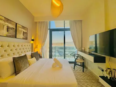 a hotel room with a bed and a large window at Venduras - Modern Chic Studio in Azizi Riviera in Dubai