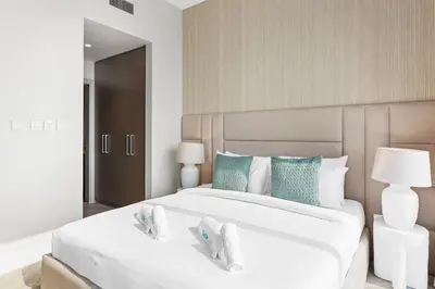a bedroom with a large white bed with blue accents at Luxurious Living in a 2 Bedroom at Forte Downtown in Dubai