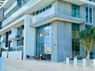 a building with a sign on the front of it at Stunning 2 Bedroom in Emaar Beachfront in Dubai