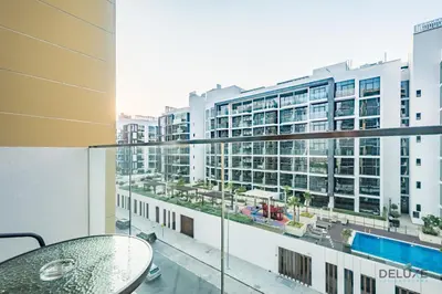 a balcony with a table and a view of a building at Charming 1BR Apartment in Azizi Riviera 30, Al Merkadh by Deluxe Holiday Homes in Dubai