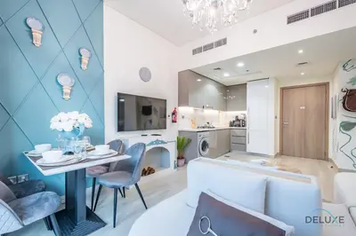 a living room with a table and chairs at Charming 1BR Apartment in Azizi Riviera 30, Al Merkadh by Deluxe Holiday Homes in Dubai