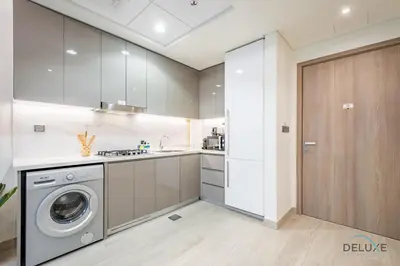 a kitchen with a washing machine and a washer at Charming 1BR Apartment in Azizi Riviera 30, Al Merkadh by Deluxe Holiday Homes in Dubai